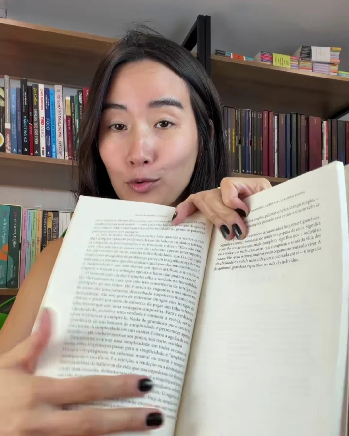 Leitora mostrando as páginas abertas do livro