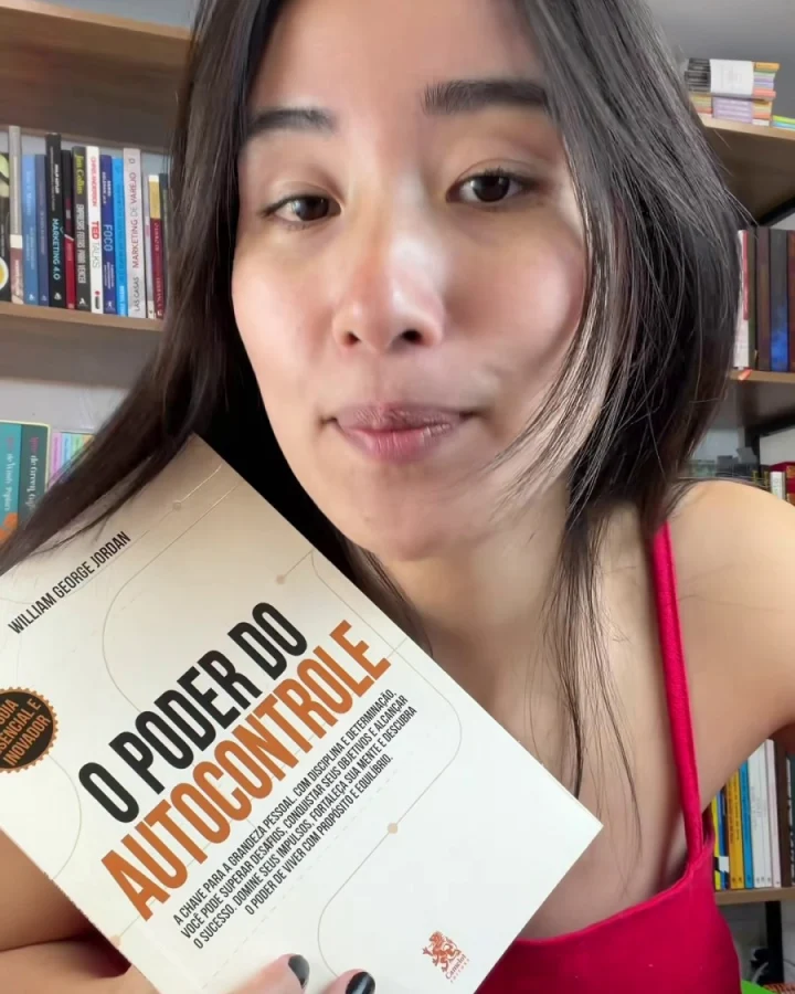 Leitora mostrando a capa do livro O Poder do Autocontrole